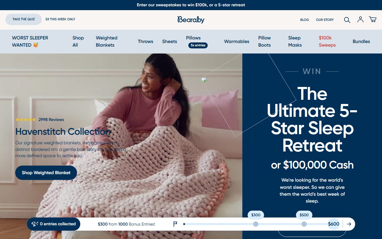 Bearaby官网首页截屏，顶部公告条Enter our sweepstakes to win $100k or a 5-star retreat，导航含TAKE THE QUIZ/Shop All/Weighted Blankets/Throws/Sheets/Pillows/Warmables/Pillow Boots/Sleep Masks/$100k Sweeps/Bundles，hero为粉色针织重力毯Havenstitch Collection与WORST SLEEPER WANTED抽奖
